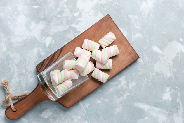 木板顶视图彩色美味的棉花糖小糖果形成浅白色的办公桌上茶木头顶部