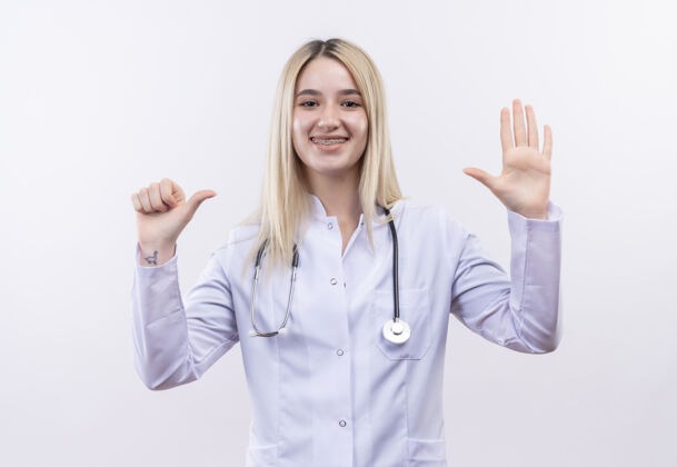 白人微笑的医生年轻的金发女孩戴着听诊器和医用长袍 戴着牙套 在孤立的白色背景上显示出不同的姿势医疗微笑不同