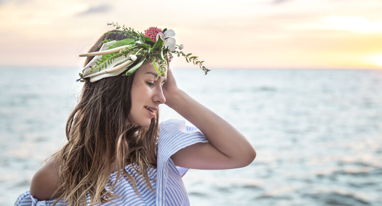 女人日落时大海背景下一位头戴鲜花的年轻女子的肖像画海洋休息天空