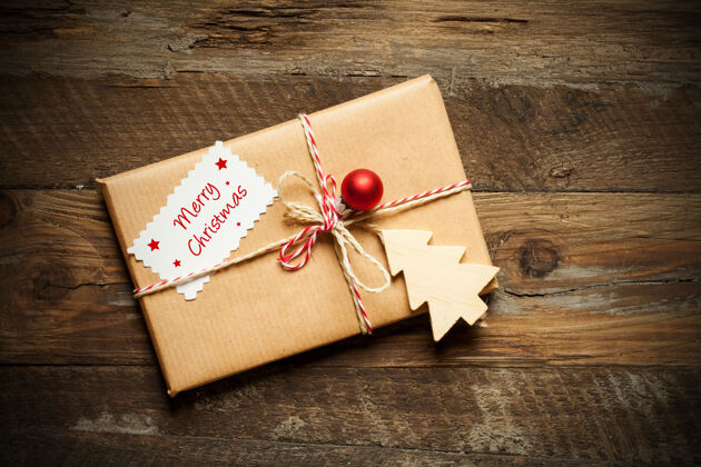 传统木制表面上包装好的圣诞礼物的顶视图 卡片上写着圣诞快乐冬天盒子季节