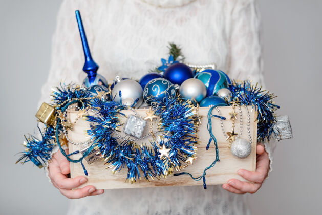 树枝一个人拿着一盒圣诞装饰品的特写镜头快乐季节举行