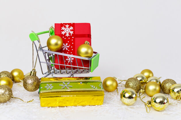 手推车购物手推车与礼品盒和金色球体上的雪花在白色的背景盒子购物圆形
