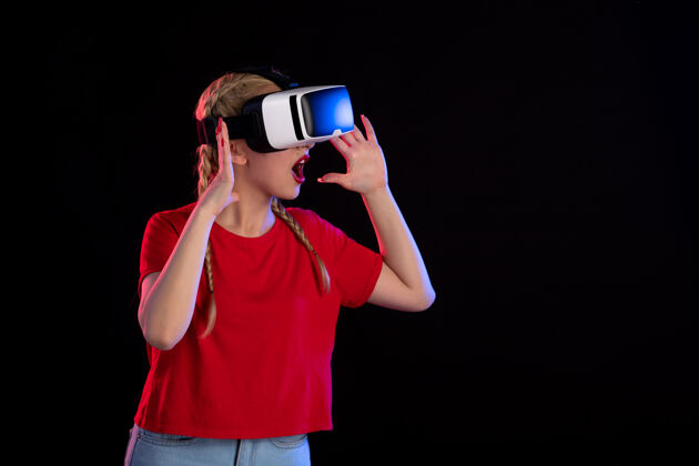 年轻女性年轻女性在黑暗中玩虚拟现实超声视觉游戏的正面图虚拟现实视觉磁盘骑师