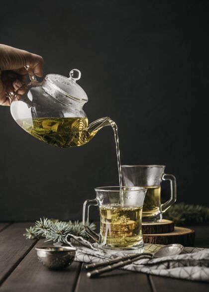 饮料正面图用茶壶手在玻璃里倒茶热芳香传统