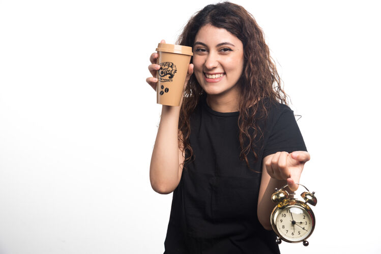 人微笑的女人展示一杯咖啡 白色背景上有时钟高质量的照片咖啡时钟微笑