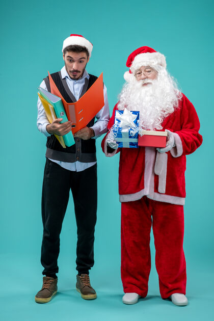 视图前视图圣诞老人与年轻的男性和礼物蓝色地板雪新年圣诞假期圣诞老人蓝色套装