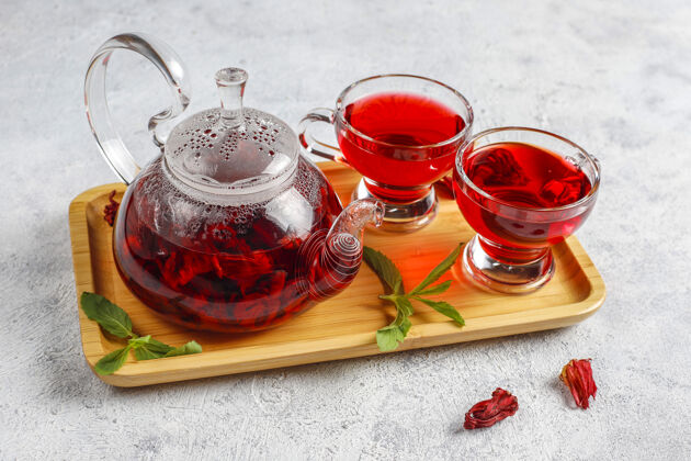 肉桂热木槿茶在一个玻璃杯子和玻璃茶壶植物花新鲜