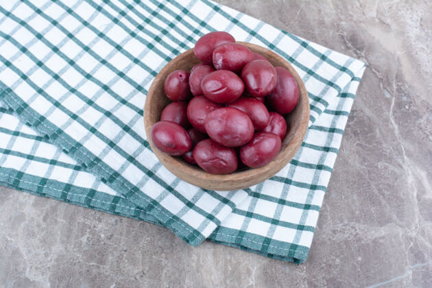 发酵的用桌布把腌制的水果放在木碗里桌布水果酸的