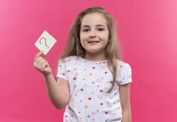 马克微笑的小女生穿着白色t恤 手拿纸问号 背景是孤立的粉色问题粉色小