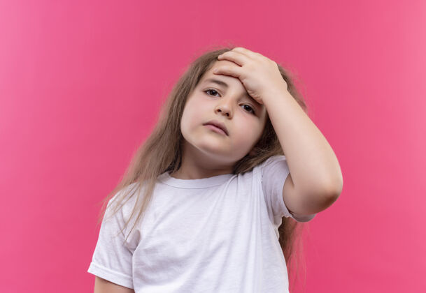 穿着生病的小女孩穿着白色t恤把她的手放在孤立的粉红色背景前额手女孩生病