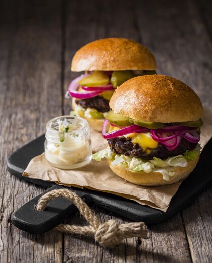 芝士汉堡高角度的汉堡和腌菜在砧板上快餐食物午餐