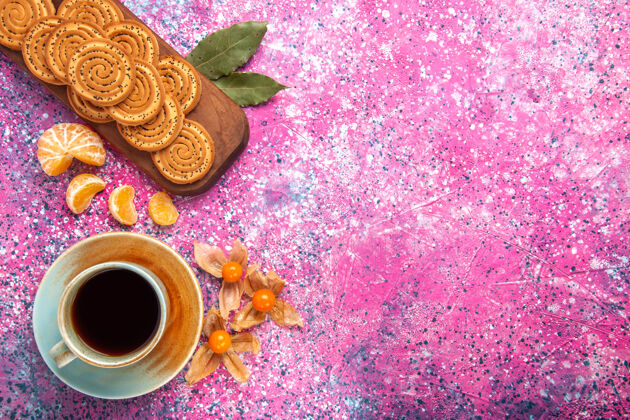 饮料在粉红色的表面上有一杯茶和橘子的甜饼俯视图糖果美味的热的