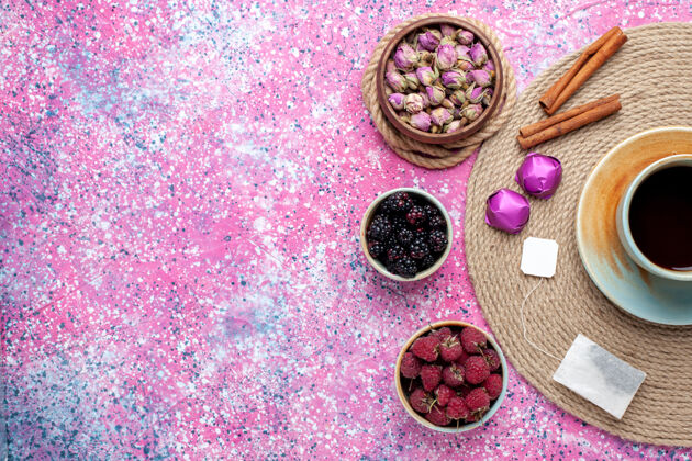 水果顶视图新鲜浆果 覆盆子和黑莓 配一杯茶 肉桂和粉色书桌浆果五颜六色茶