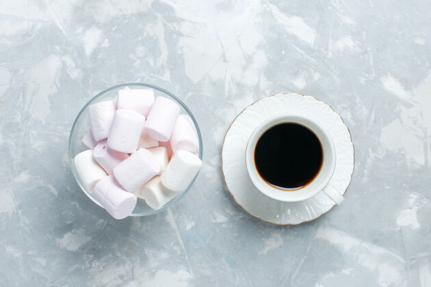 棉花糖在浅白色的桌子上放一杯带棉花糖的茶饮料杯子棕色