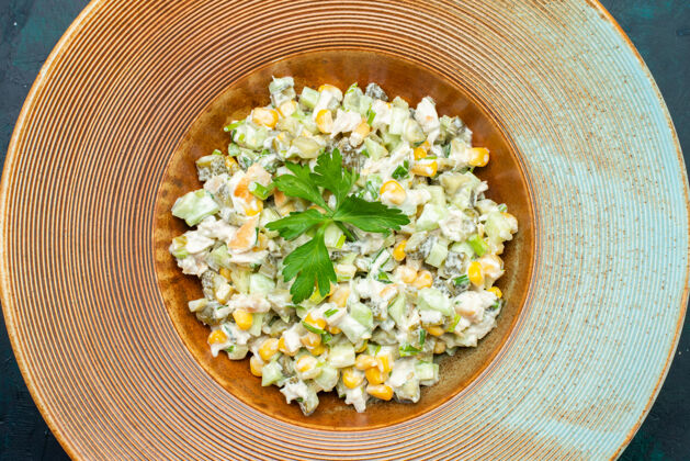 大米在深蓝色桌子上的盘子里俯瞰美味的蔬菜沙拉蓝色盘子谷物