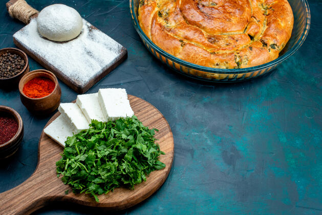 食物半俯视图白色奶酪 蓝色背景上有绿色糕点和调味品盘子菜调味品
