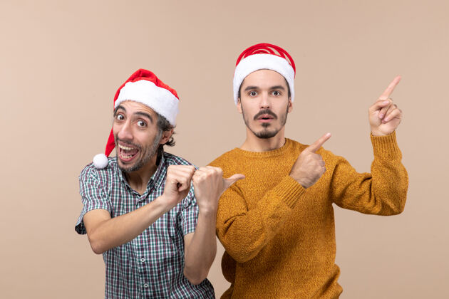 帽子正面图两个男人一个高兴 一个悲伤 戴着圣诞帽 都在孤立的背景下展示了一些东西悲伤男人帽子