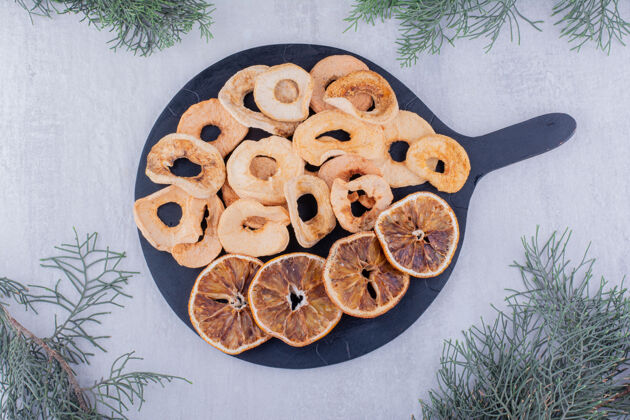 开胃一堆干苹果和橘子片放在白色背景的小托盘上干燥柑橘芳香