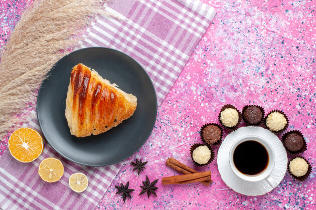 切片蛋糕片的俯视图 粉色表面有肉桂茶和巧克力糖果桌子糕点生的