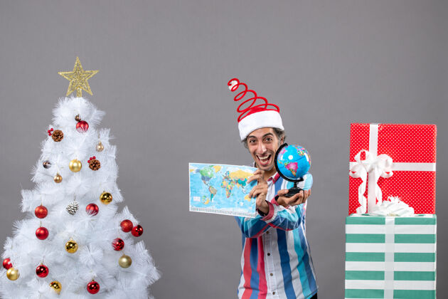假期前视图快乐的人显示世界地图和地球仪圣诞节展示男人