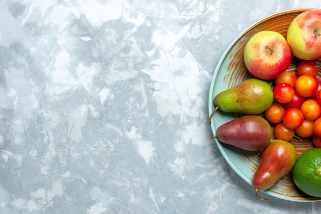 苹果顶视图水果组成苹果梨橘子和李子在浅白色的桌子上苹果健康柑橘