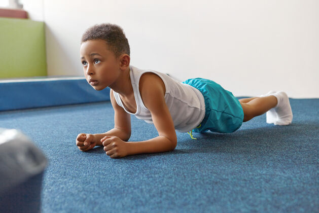 肘部一个穿着运动服的非洲裔美国男孩在健身房里自作主张室内活跃肖像