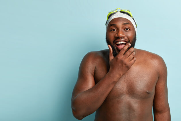 牙齿皮肤黝黑的快乐赤膊男 喜欢游泳 娱乐和健身 抱着下巴 积极凝视肌肉射击下巴