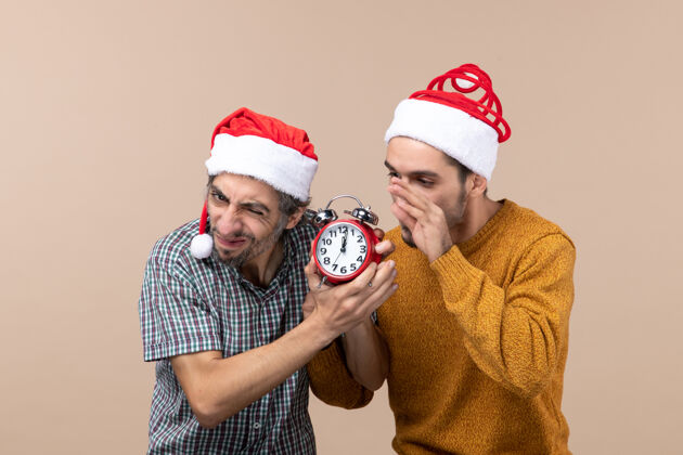 男人前视图：两个心烦意乱的人想在米色的孤立背景上关掉时钟钟不安头饰