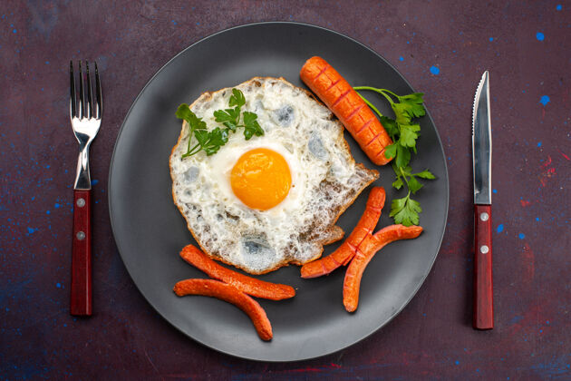 晚餐顶视图炒鸡蛋与绿色和香肠内板在黑暗的表面香肠午餐菜