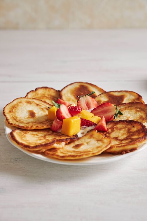 自制白木桌上美味的水果煎饼的垂直镜头餐美味盘子