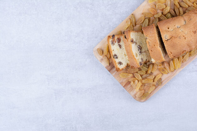 切板在木板上放一堆葡萄干的甜面包甜点葡萄干面包房