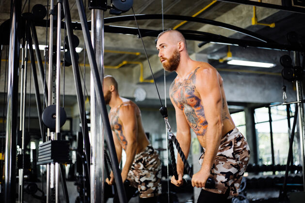 向上拉纹身的健康男人在健身房锻炼力量拉运动员