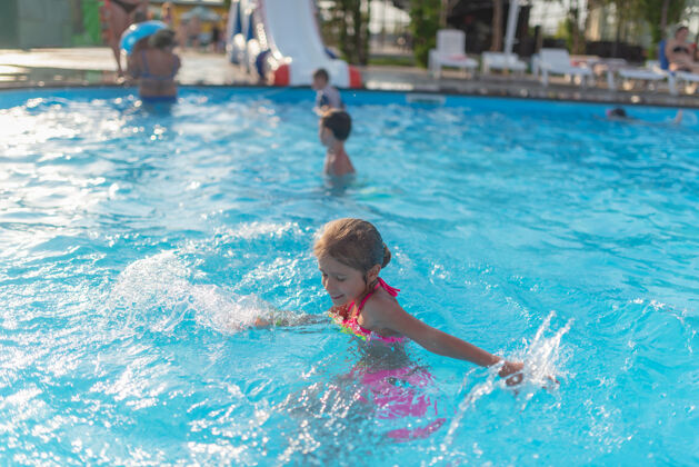 人顶视图快乐的小女孩在明亮的颜色泳装游泳在清澈温暖的游泳池水阳光明媚的夏日度假家庭度假和旅游概念娱乐游泳池女孩