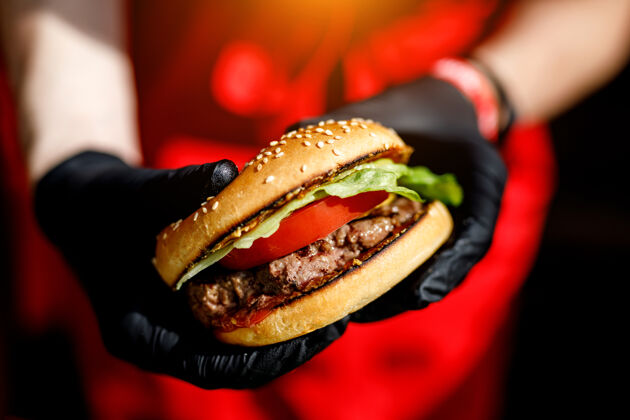 烧烤男人手里拿着美味的汉堡 戴着黑手套午餐餐厅法国