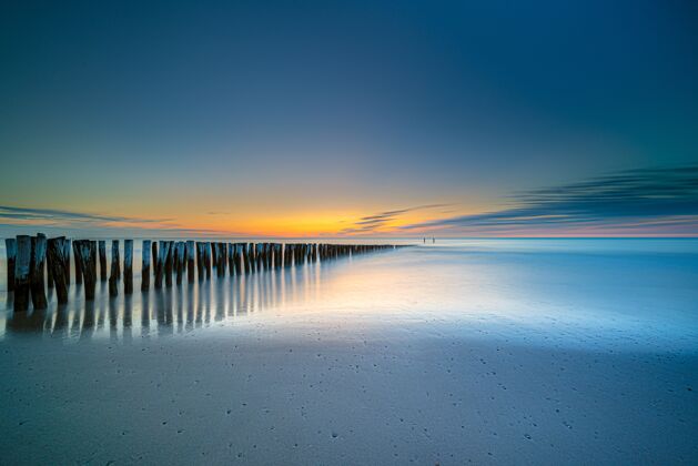 日落日落时 海边通往大海的木质甲板的高角度拍摄海岸沙滩海滩