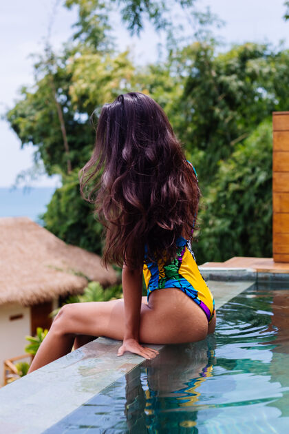 享受年轻漂亮的积极快乐的苗条女子 穿着五颜六色的泳衣 在豪华的酒店别墅享受泰国度假的美好日子肖像海滩游泳