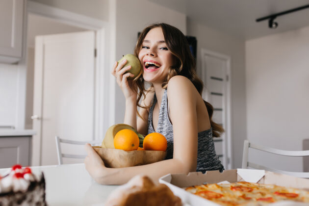 微笑快乐的白人女孩吃着美味的苹果和橘子浪漫的女模特享受着健康的饮食营养表情快餐
