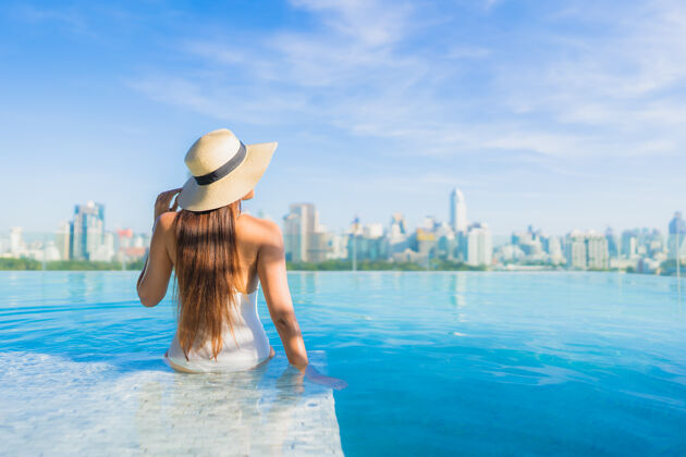 比基尼美丽的亚洲年轻女子在户外游泳池周围放松 城市景色尽收眼底外部身体豪华
