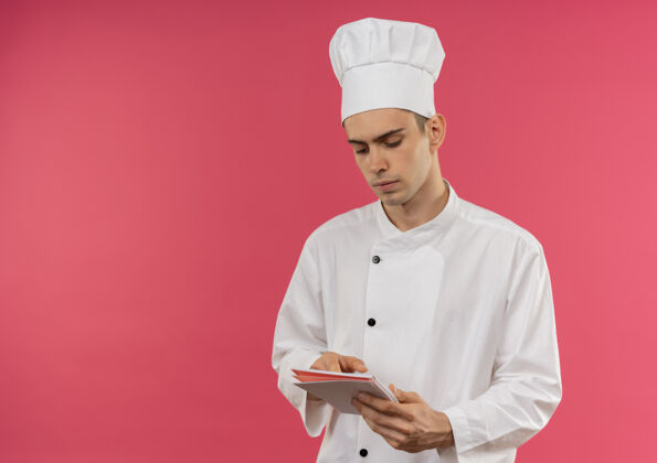 拿着想着年轻的男厨师穿着厨师制服拿着笔记本看着有复印空间戴着笔记本制服