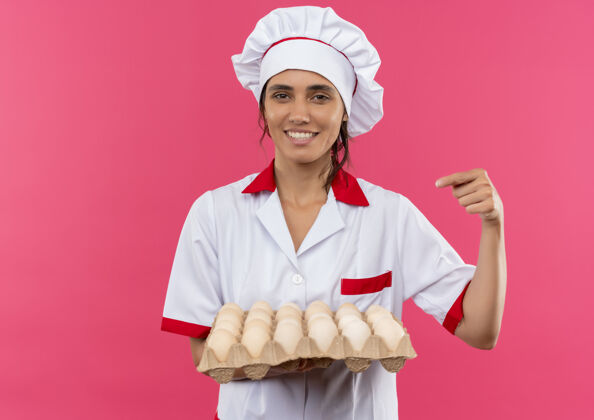 鸡蛋年轻的女厨师面带微笑 穿着厨师制服 拿着一批鸡蛋点着复印空间分女穿