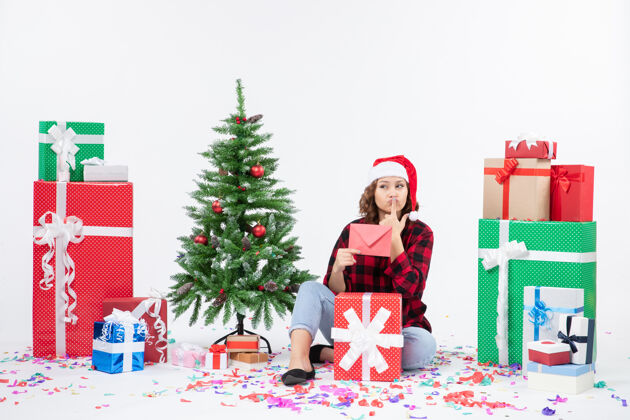 信封前视图年轻女子围坐在一个白色的墙上拿着信封的礼物快乐礼物礼物
