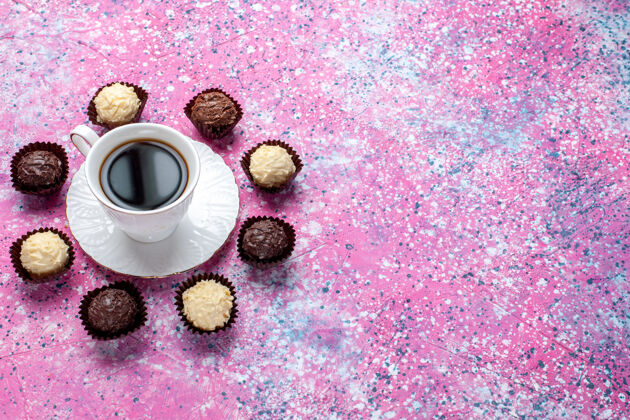 白色半俯视美味的巧克力糖果白色和黑色巧克力与茶杯粉红色背景糖果邦邦茶