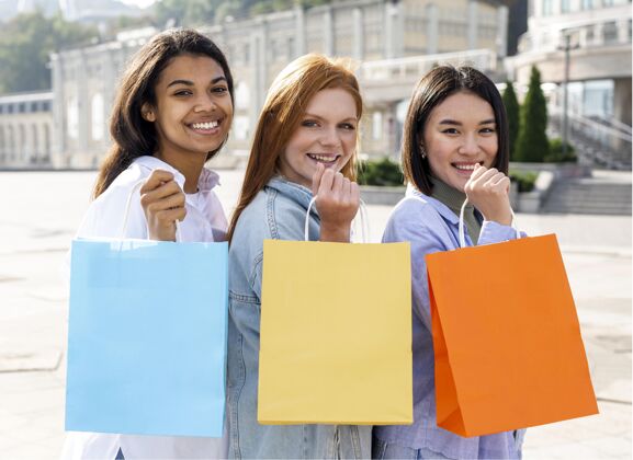 人女人们在给购物袋擦鞋朋友多样性多样性