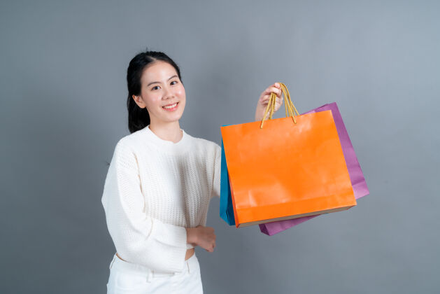 女士美丽年轻的亚洲女人拿着购物袋快乐欢呼人