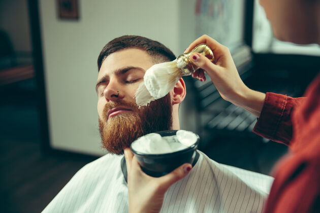 客户客户在理发店剃须女理发师在沙龙性别平等女性在男性职业发型师剪刀肥皂