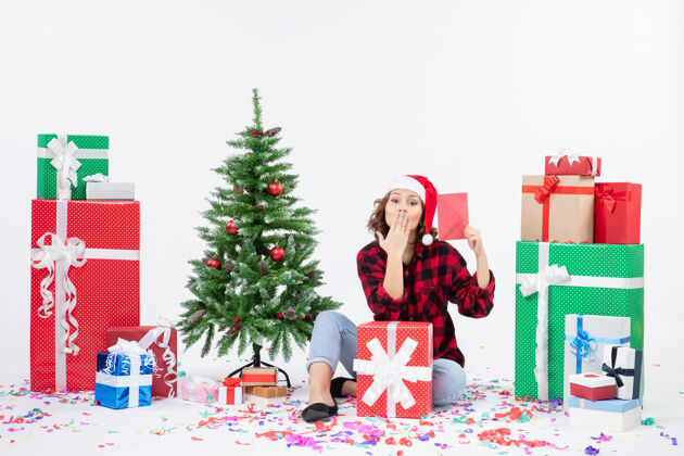 礼物前视图：年轻女子围坐在白墙上 手里拿着信封快乐雪情感