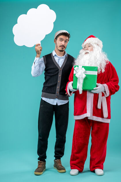 白色前视图圣诞老人和年轻的男性谁持有白云标志蓝色背景年轻圣诞前面
