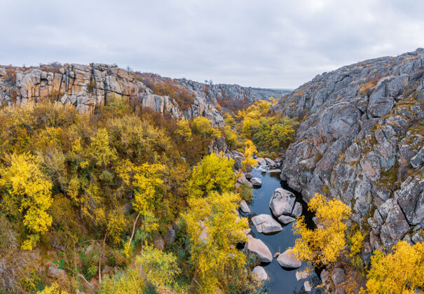 夜晚一条小溪在乌克兰的阿克托夫斯基峡谷中流过秋树和大石头围绕着它峡谷石头瀑布