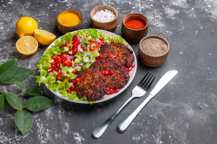 蔬菜顶视图美味的肉排与沙拉和调味品在灰色的背景菜肉饮食餐