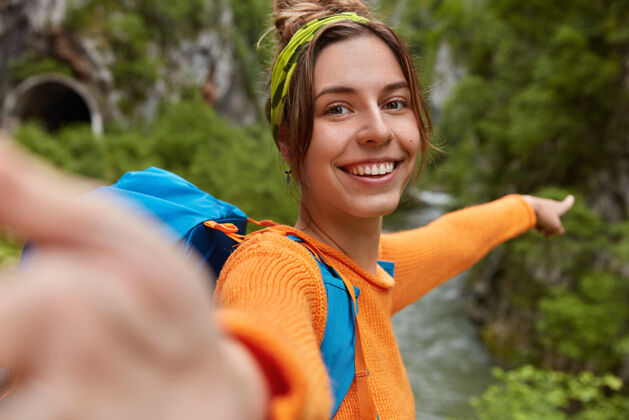 徒步旅行积极的女博客在网上拍摄视频 探索自然 指向远方背包客伸展展示